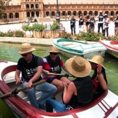 Equipo de empleados participando en una actividad de team building en barcas en la Plaza de España de Sevilla, como parte de una experiencia corporativa.