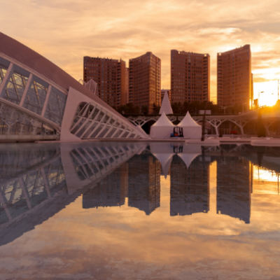 Vista de la Ciudad de las Artes y las Ciencias de Valencia al atardecer con reflejo en el agua, espacio emblemático para eventos corporativos y actividades para empresas.