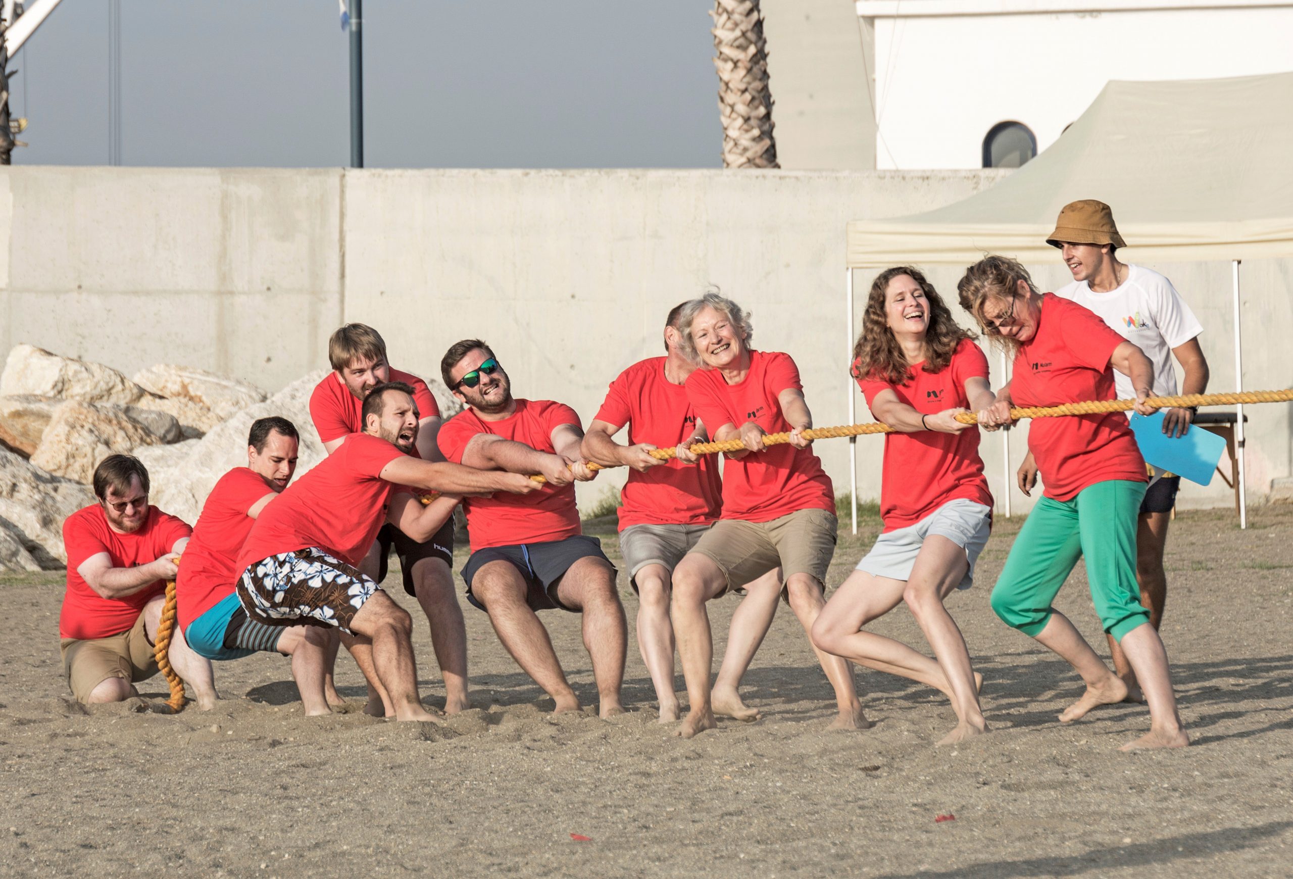 Equipo participando en actividad team building en la playa durante el verano
